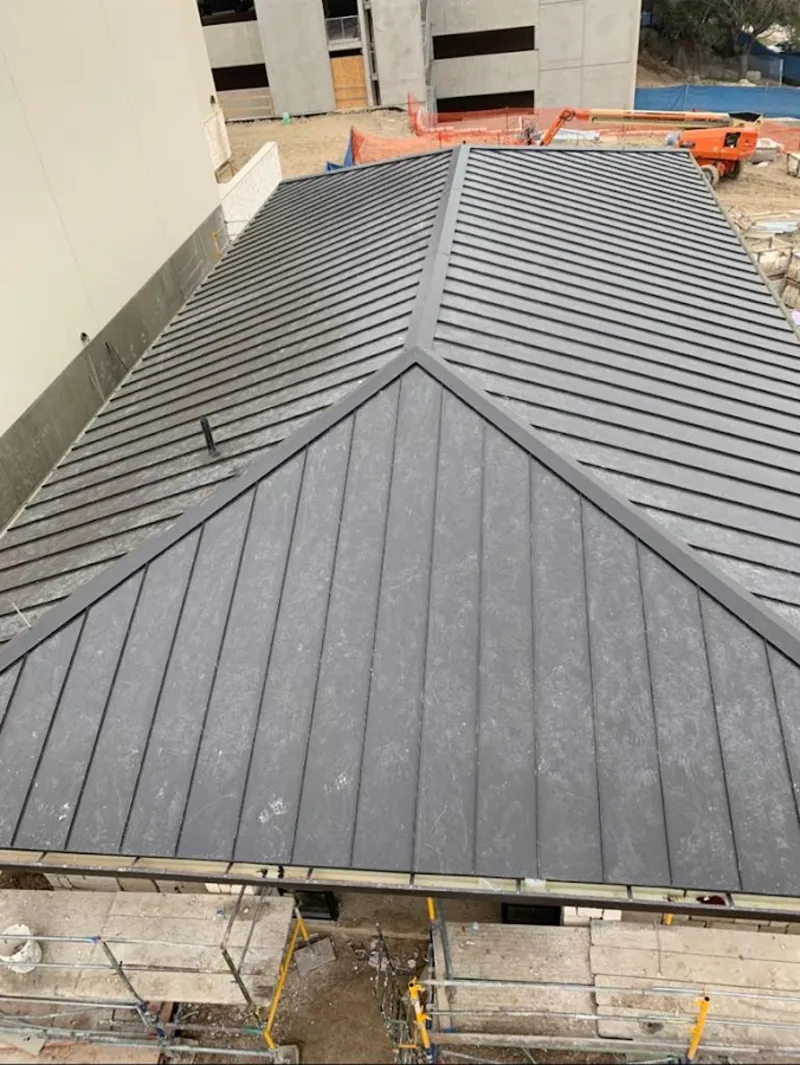 Commercial metal roof construction with crane equipment in Bixby